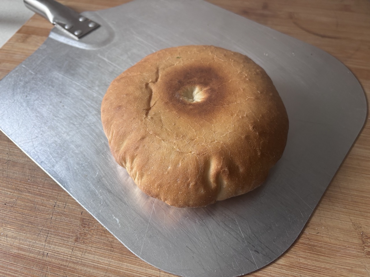 A home-baked stottie cake on a metal baking peel